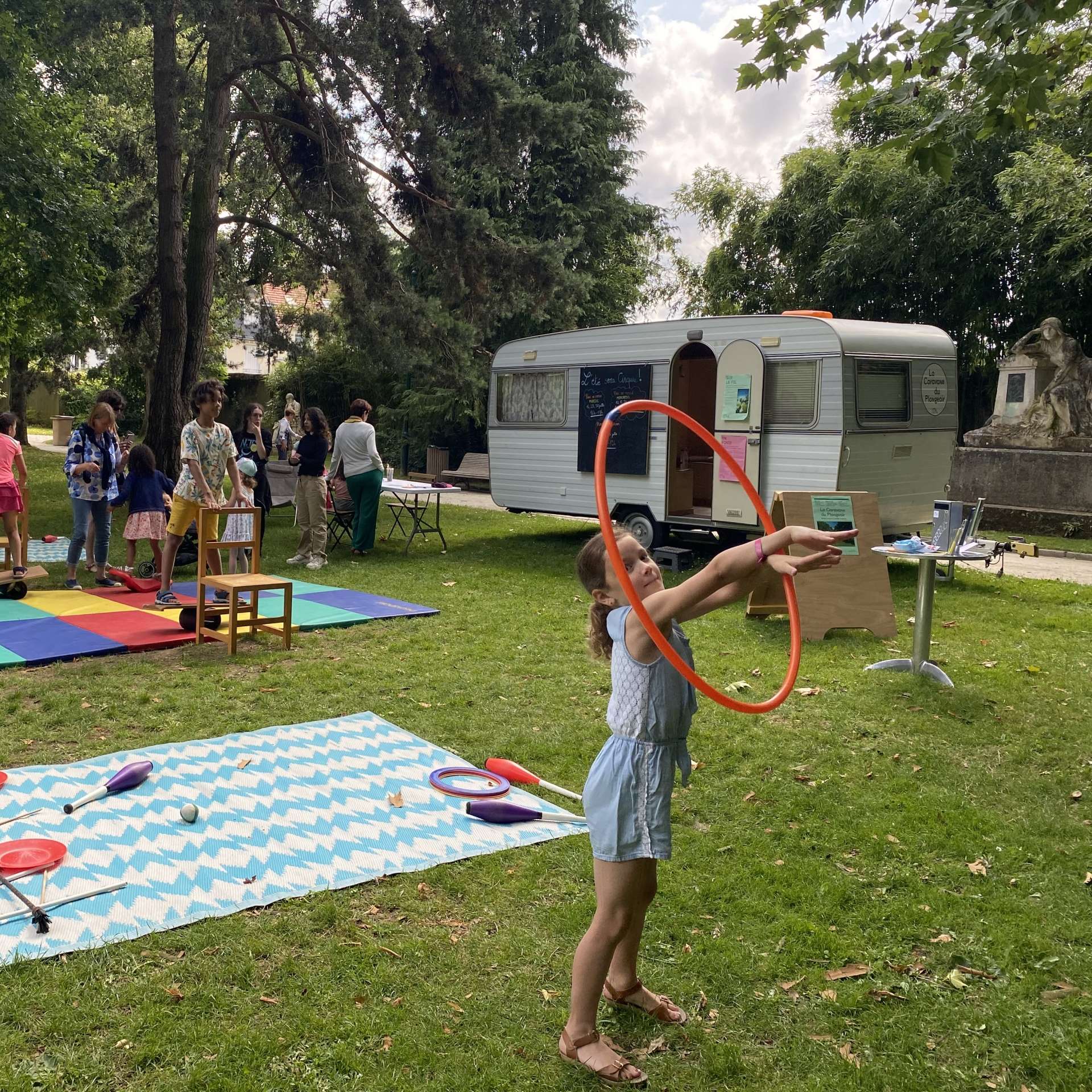 une enfant manipule un cerceau dans un parc