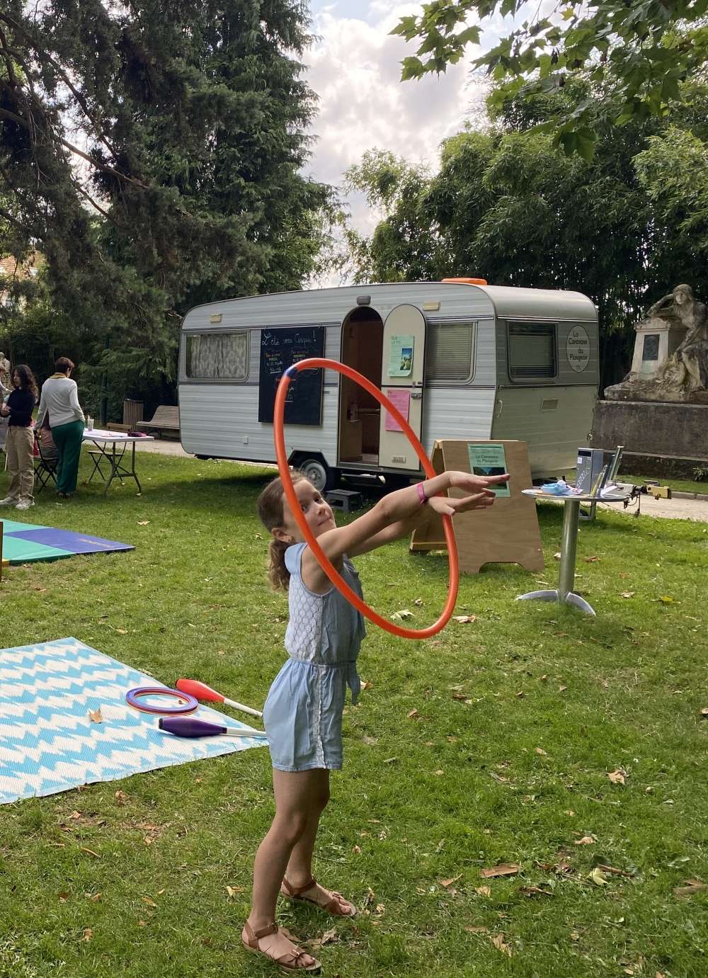 une enfant manipule un cerceau dans un parc