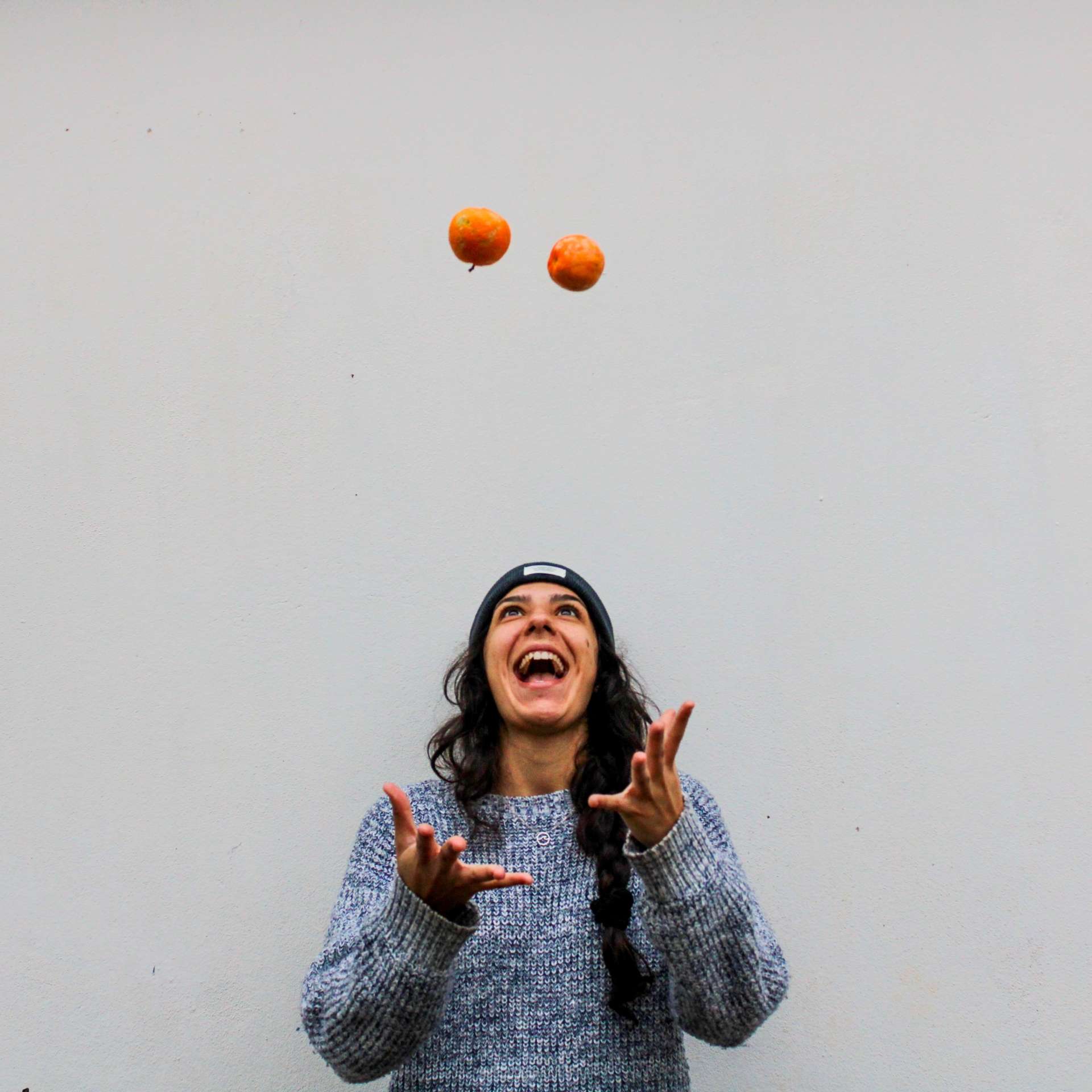 Une personne jongle avec des oranges