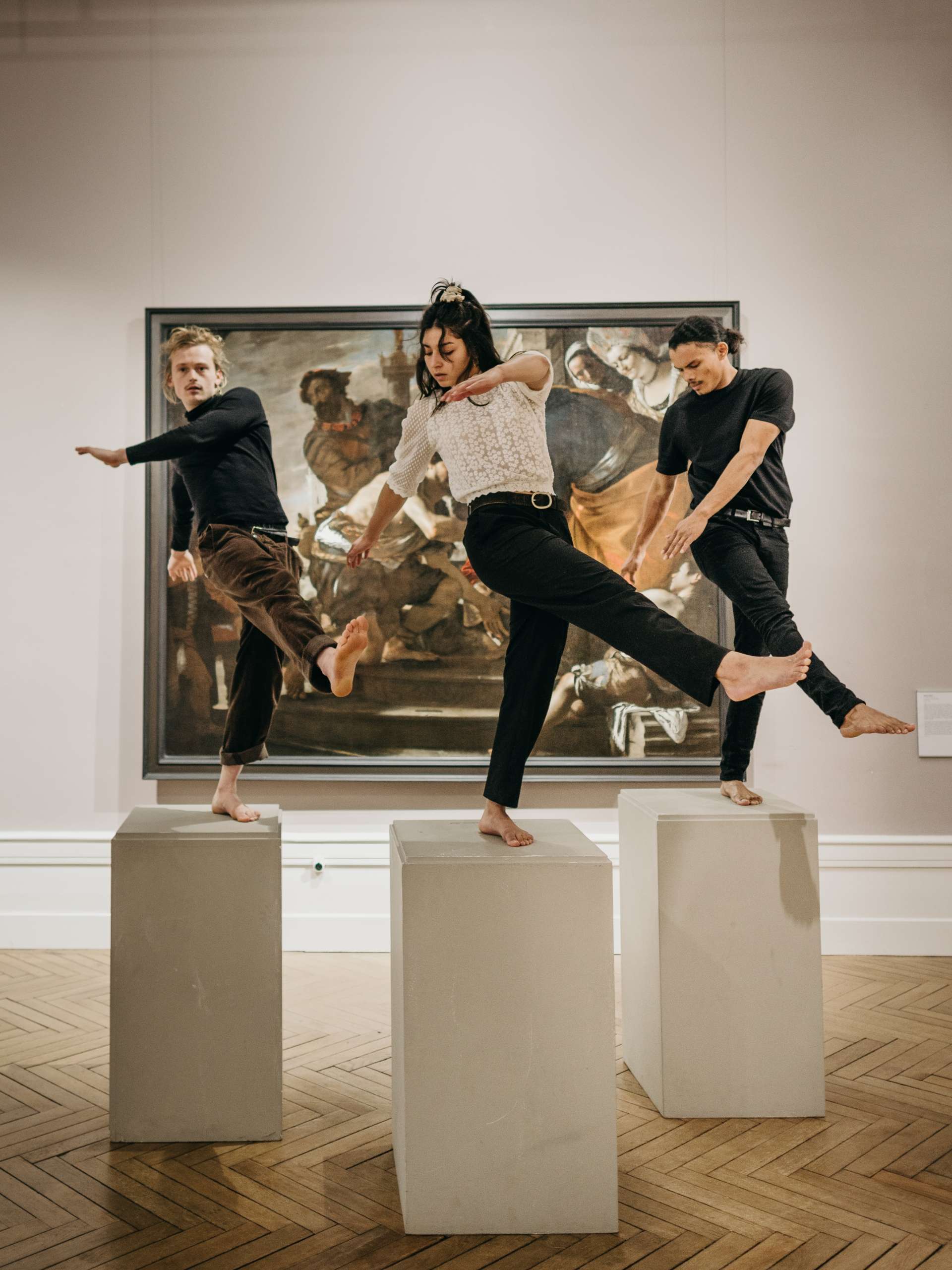 Trois circassiens en sur un plot devant une toile au Musée