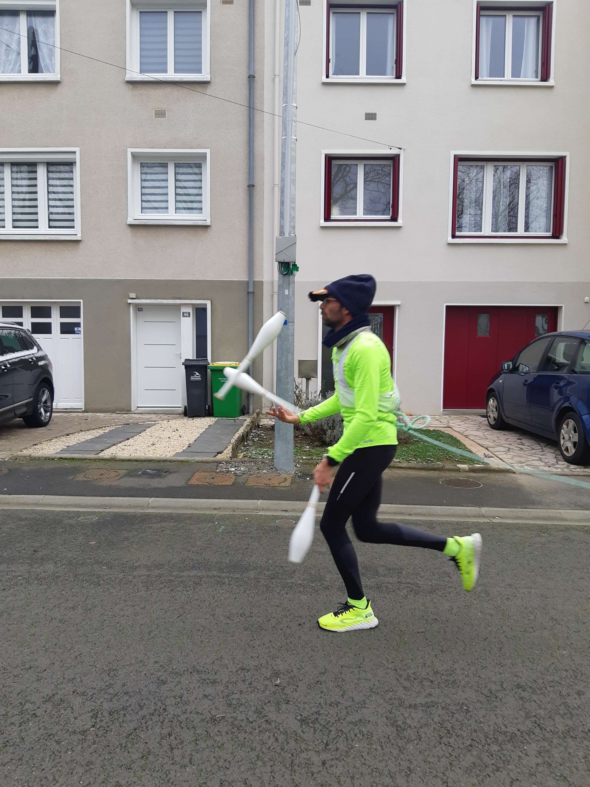 Un jongleur court dans une rue résidentielle