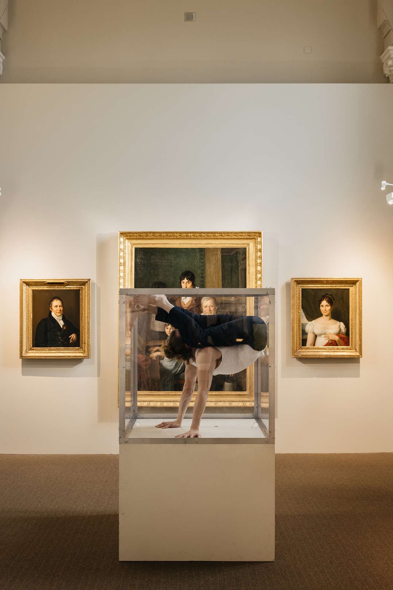 L'acrobate se contorsionne dans une vitrine d'exposition