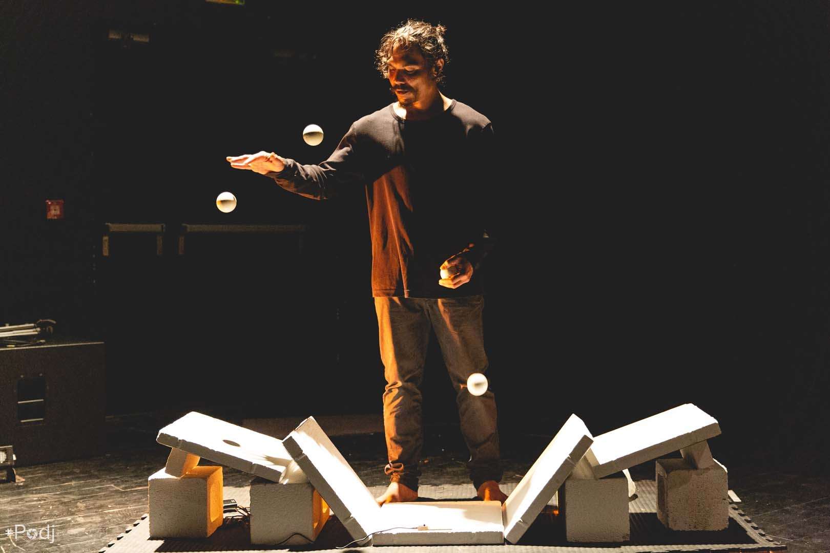 Un jongleur fait rebondir des balles sur des parpaings