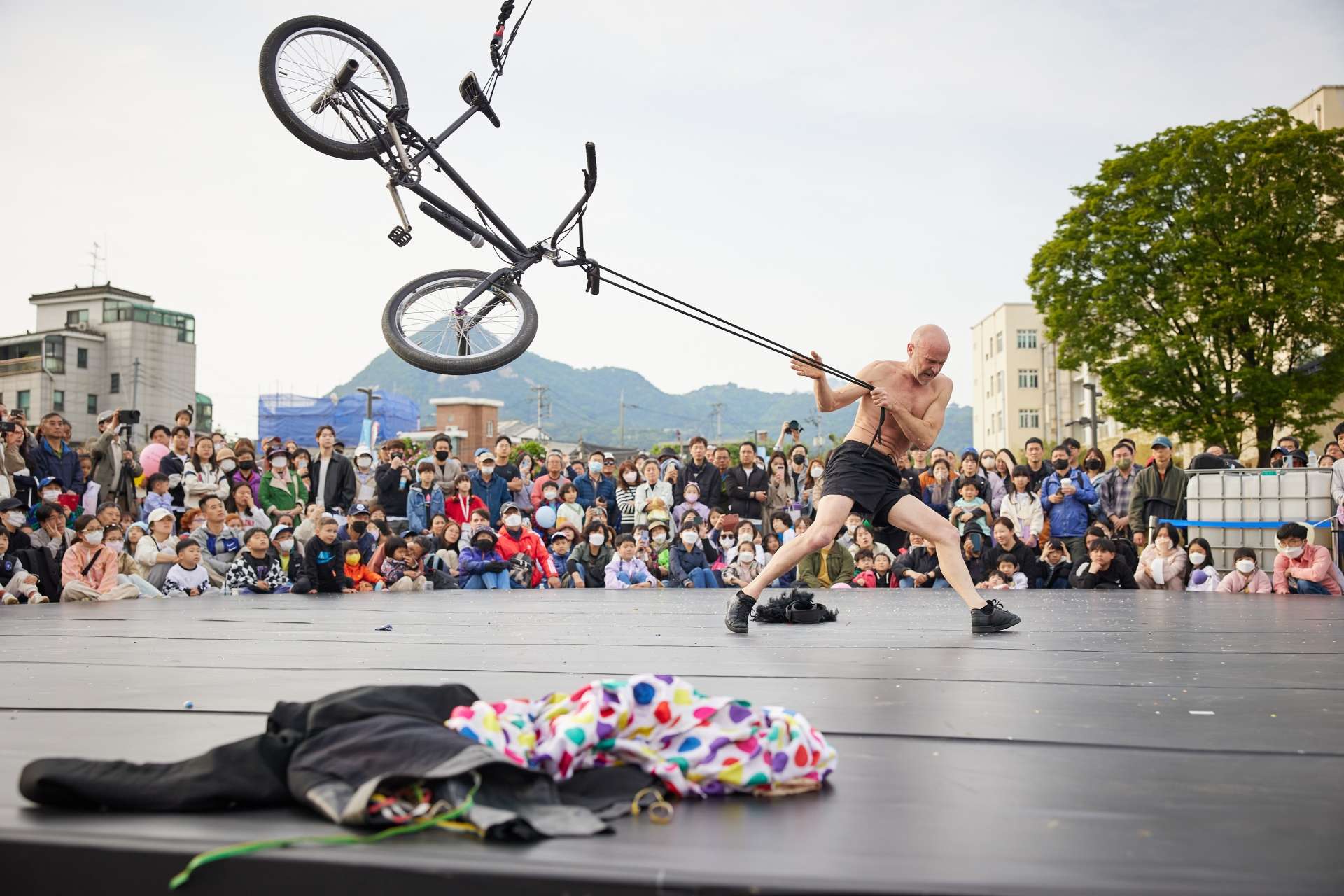 Un homme fait voltiger un vélo BMX au bout d'une sangle