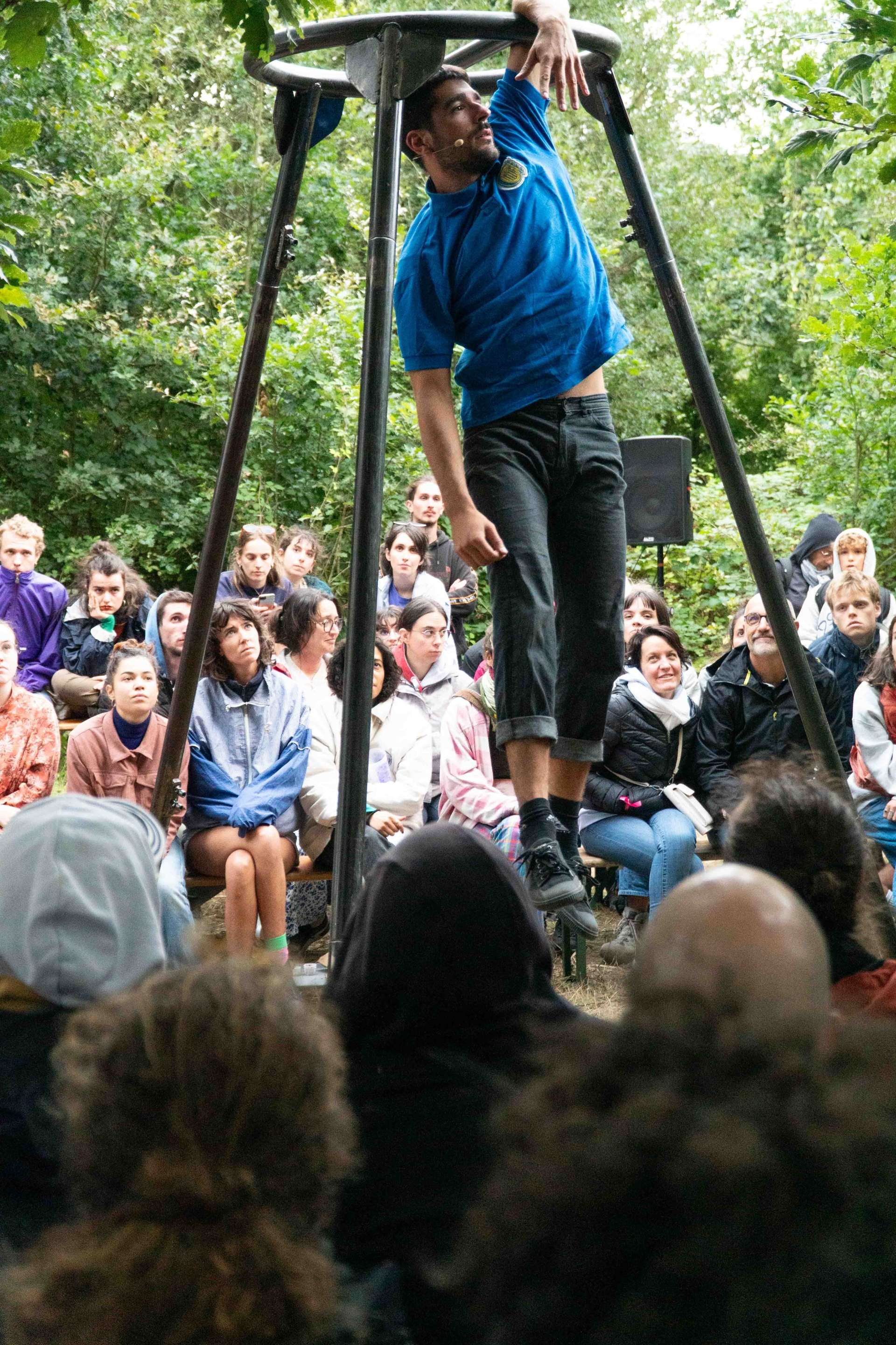 Un homme se suspend à un portique au milieu du public