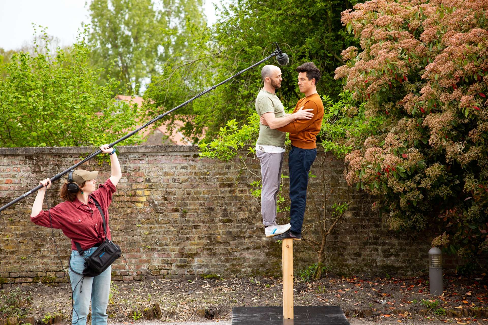 Deux hommes se tiennent debout sur un bastaing de bois