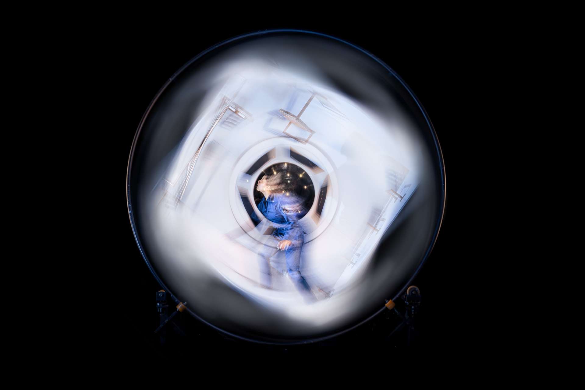 une femme se trouve au milieu d'une structure circulaire qui tourbillonne