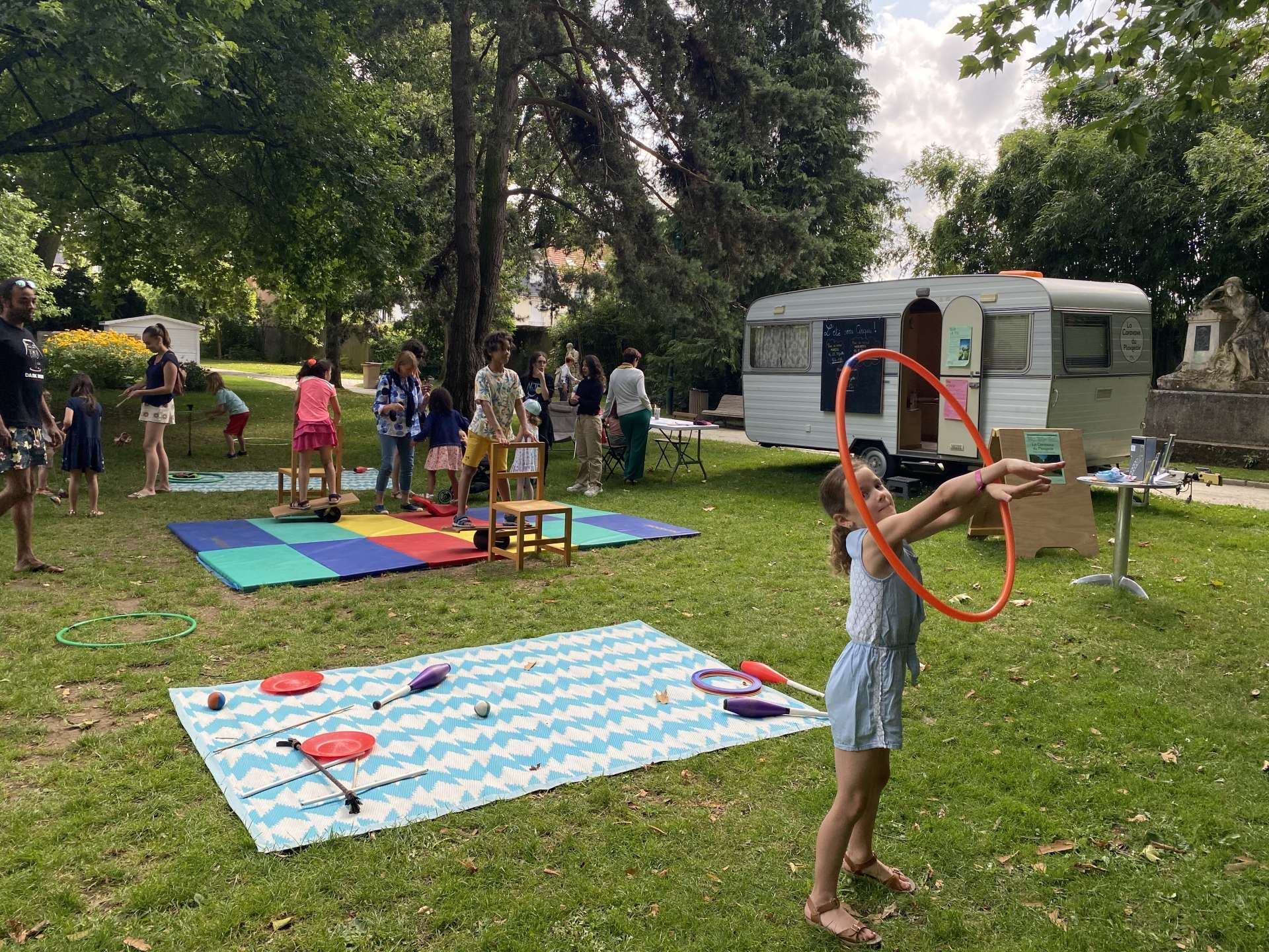 une enfant manipule un cerceau dans un parc