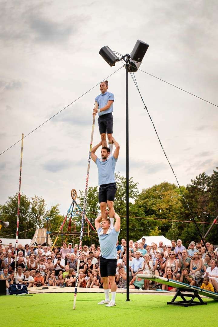 trois acrobates en équilibre les uns sur les épaules des autres