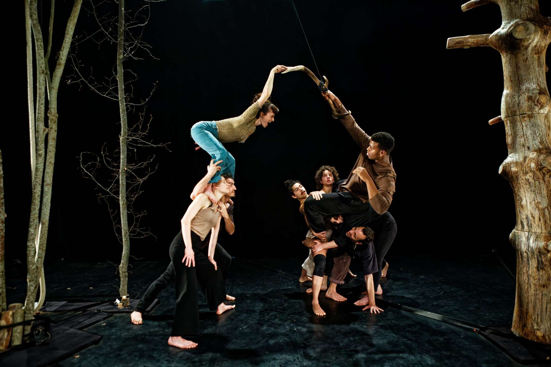 Des acrobates évoluent sur scène dans une forêt d'arbres